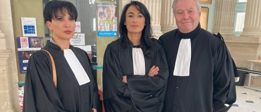 Drei Anwältinnen und Anwälte der Kanzlei in Robe in der Eingangshalle des Gerichts