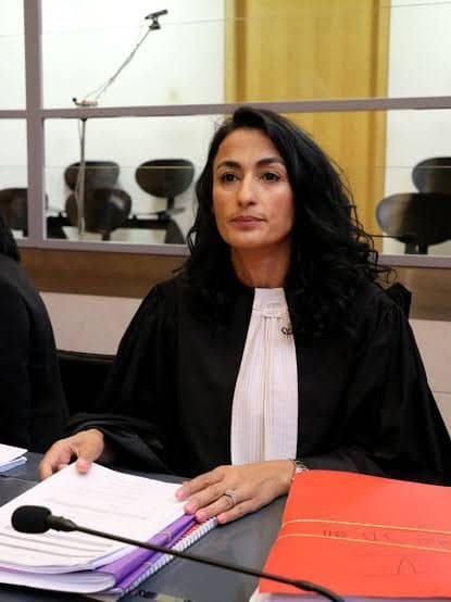 Rechtsanwältin der Kanzlei am Sitzungstisch mit aufgeschlagenen Akten
